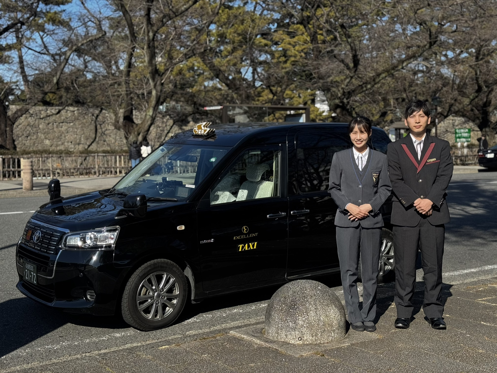 笑顔のドライバーとタクシー車両。